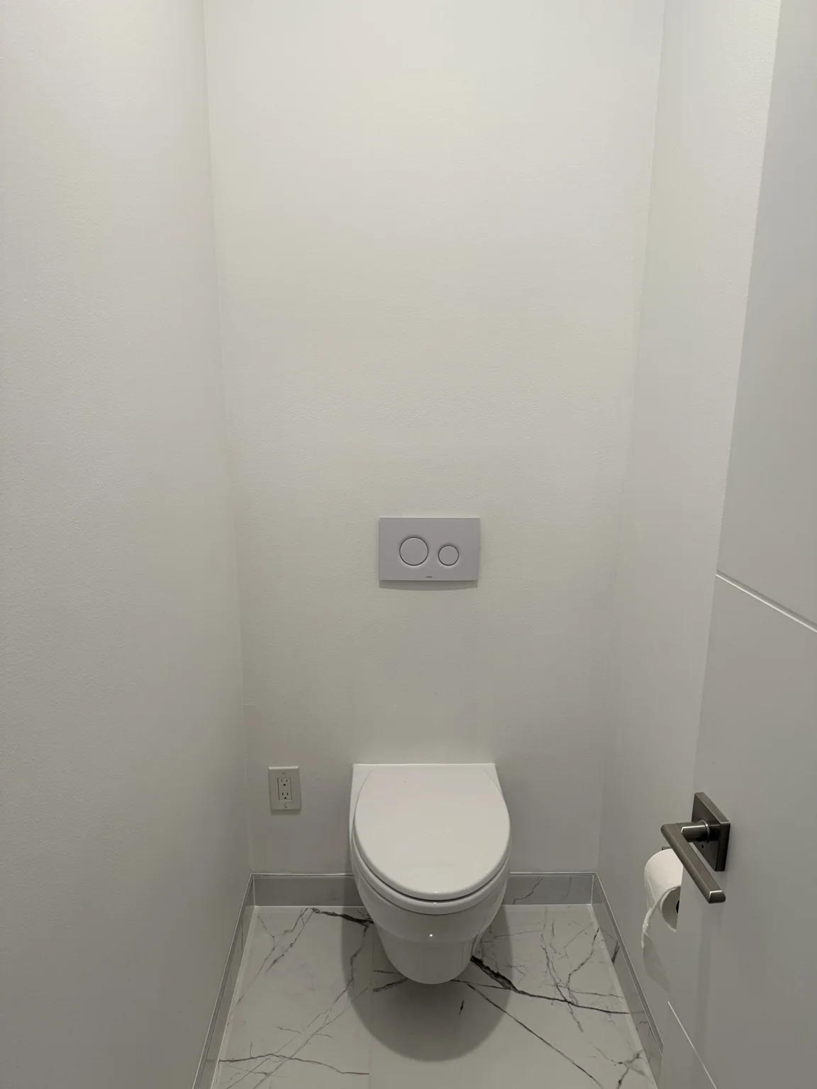 Light bathroom walls around a toilet and tiled floor