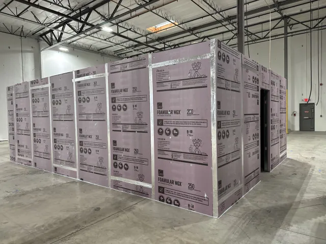Rigid foam panels installed around the exterior of the metal-framed enclosure