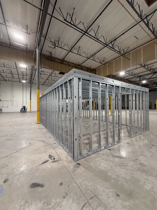 Metal-framed enclosure with wall studs and door openings