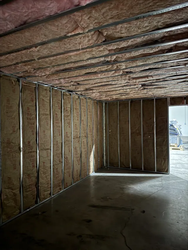 Insulation installed within metal wall and overhead framing cavities