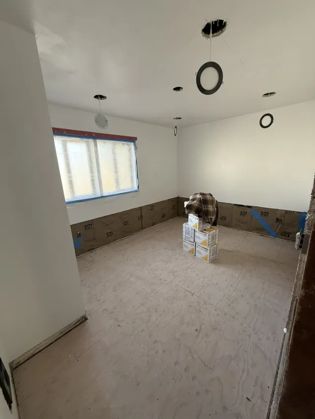 Room with protected window and wall finishing materials during renovation