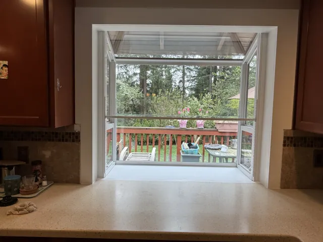Finished kitchen window viewed above the countertop with white interior trim