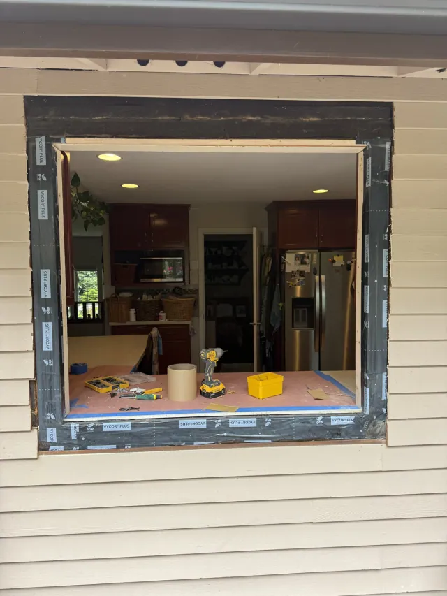 Kitchen window opening with flashing tape visible before the replacement window is installed