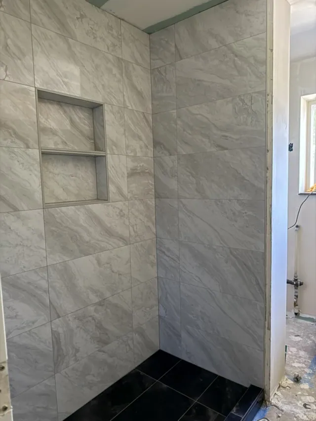 Marble-look shower tile by Remodel Tsaruk LLC